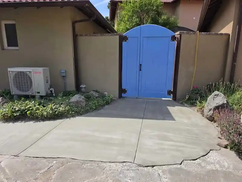 After: the same entry resurfaced smooth and sealed, at a blue garden gate