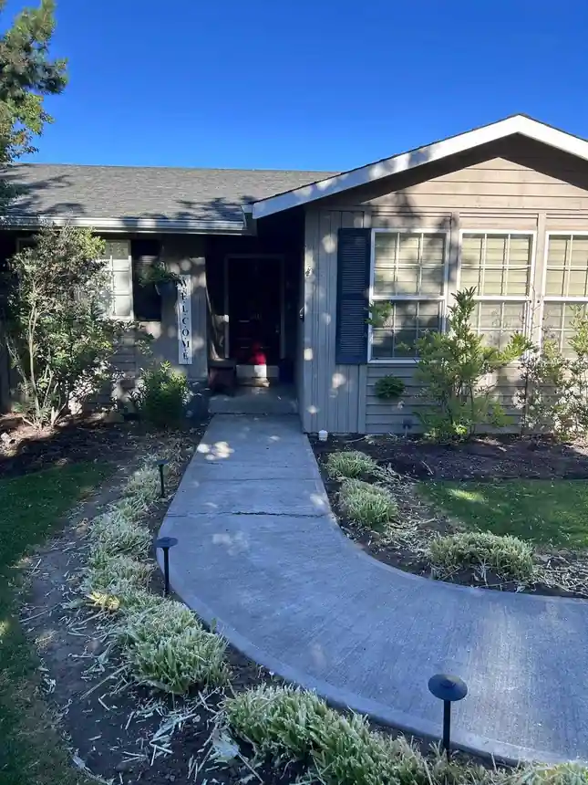 Before: a curved concrete front walkway with a crack across it, leading to a house entry