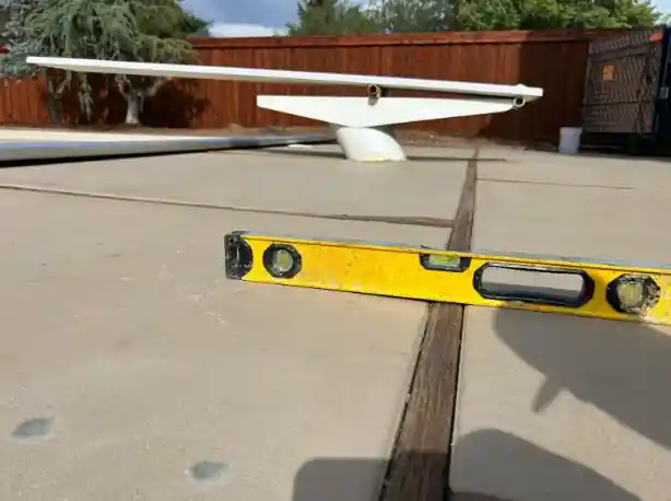 Before: a yellow level across a patio joint, the slabs on either side sitting at different heights